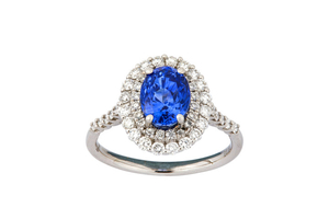 A sapphire and diamond cluster ring The oval-cut...