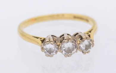 A three-stone diamond and 18ct gold ring, total diamond weight...