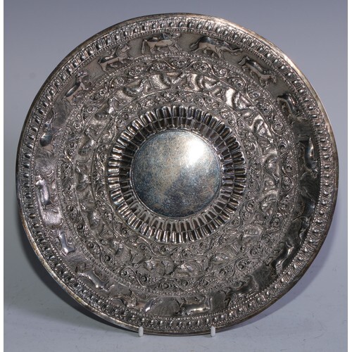 An Indian silver coloured metal salver, embossed with wild a...