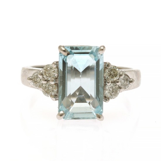 An aquamarine and diamond ring set with an emerald-cut aquamarine weighing app. 3.43 ct. flanked by siz brilliant-cut diamonds, mounted in 14k white gold.