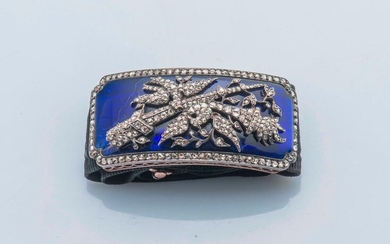 Bracelet in 18-carat gold (750 thousandths) and silver (800 thousandths) composed of a rectangular cartouche depicting two phoenixes, a sword and a torch entirely set with rose-cut diamonds, on a blue enamel background, within a rose frame. The fabric...