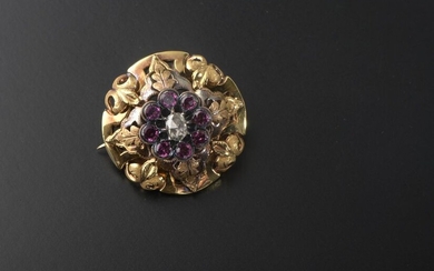 Circular brooch openworked with foliage in 18k yellow gold, adorned in the centre with an oval rose-cut diamond in an entourage of eight brilliant-cut amethysts (small shocks).