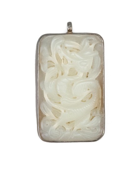 CHINESE SILVER-MOUNTED WHITE JADE PANEL Rectangular, with pierced dragon carving. Length 2".