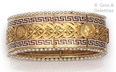 Large openwork yellow gold bracelet decorated with palmettes and profiles in medallions, supported by red and white enamelled Greek-style friezes edged with small pearls. Longueur : 18 cm. P. Brut : 71,9 g.