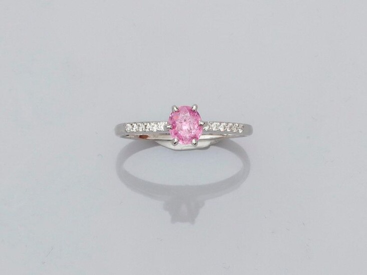 Solitaire ring in white gold, 750 MM, set with an oval pink sapphire weighing 0.61 carat between two lines of diamonds, size: 53, weight: 2.35gr. rough.