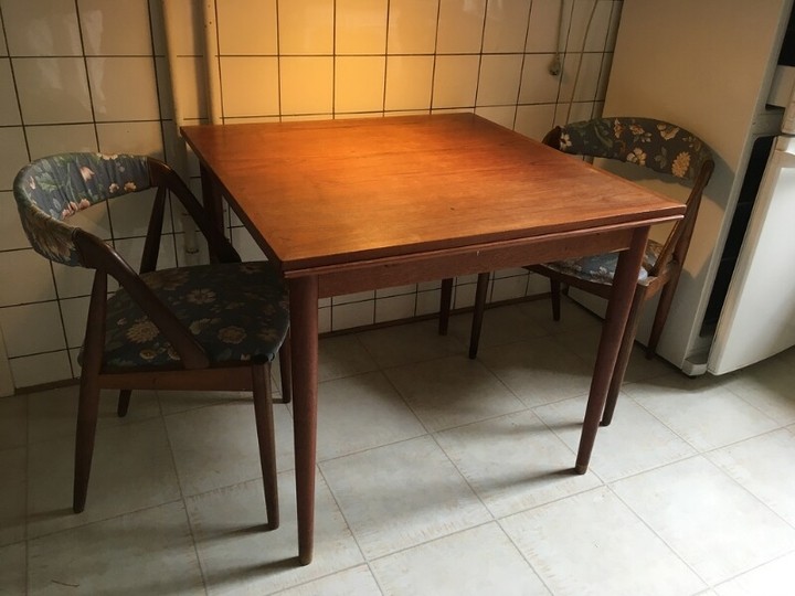 Unknown designer: A teak table with extension and two chairs, seat upholstered with floral fabric. Table H. 72 cm. L./W. 84 cm. Extension 40×2 cm. (3)