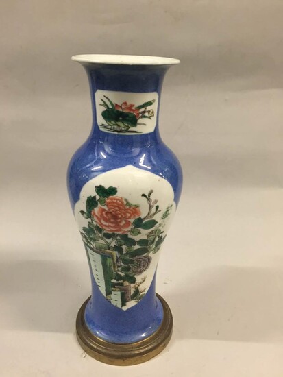 Vase balustre en porcelaine famille rose décoré de branchages fleuris en réserve sur fond bleu de poudre.