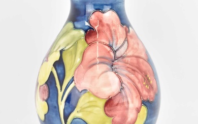 WALTER MOORCROFT; a blue ground 'Hibiscus' pattern bulbous-shaped vase, with...