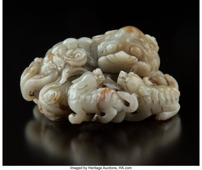 78027: A Chinese Carved Celadon and Russet Jade Lion Fi