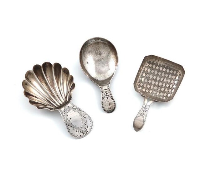 A George III silver Bright-cut caddy spoon, by John McFerlan, London 1785, shell shaped bowl, plus a George III caddy spoon, with a square bowl, chequer-board decoration, by William Pugh, Birmingham 1813, and one other, approx. weight 0.7oz. (3)
