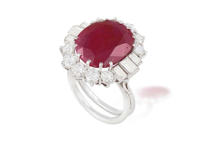 A RUBY AND DIAMOND CLUSTER RING The oval-shaped...