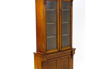 A Victorian mahogany chiffonier bookcase, the top having a m...