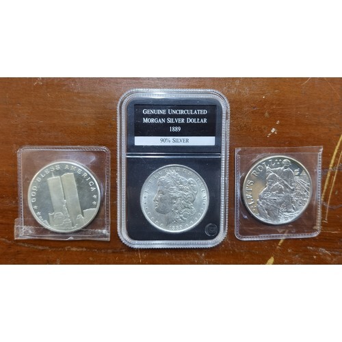 A group of four US silver coins to include a genuine uncircu...