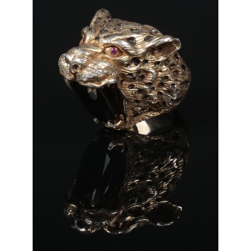 A heavy cast silver ring formed as a leopards head clutching...