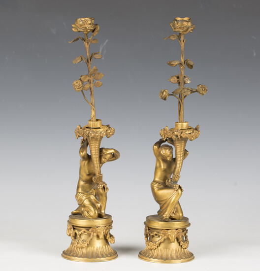 A pair of 19th century cast gilt bronze figural candlesticks, each modelled as a kneeling maiden sup