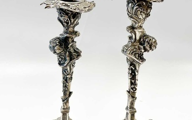 A pair of Continental silver cast candlesticks, decorated with heads, leaves and scrolls, damage and