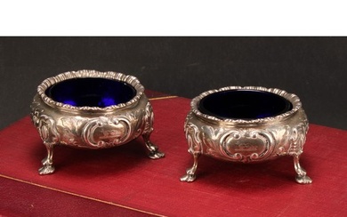 A pair of Victorian silver cauldron salts, chased with flowe...