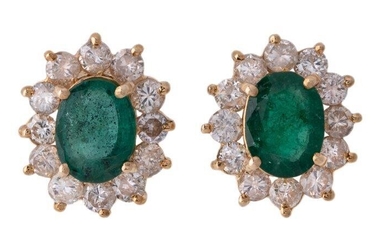 A pair of emerald and diamond earrings, cluster design, each centring on an oval emerald, framed by brilliant-cut diamonds, clip and post fittings