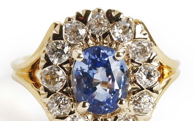 A sapphire and diamond ring set with an oval-cut natural sapphire weighing...
