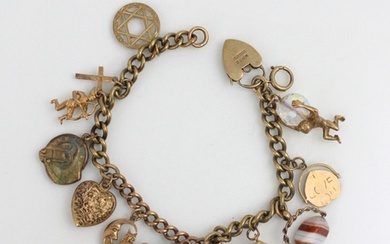 A yellow metal and gold coloured charm bracelet, the curb li...