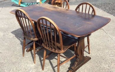 An Ercol elm dining table with rounded rectangular top on...