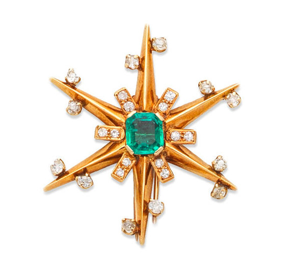 An emerald and diamond star brooch