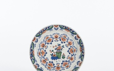 DELFT Assiette de forme pannekoek en faïence à décor bleu, rouge et vert de vases...