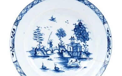 Lowestoft plate, painted in blue with a chinaman crossing a bridge with a fishing rod, a bird in flight above, diaper and half-flowerhead border, 22.8cm diameter