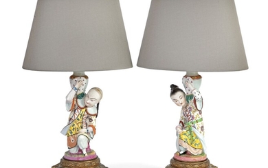 Paire de sujets en porcelaine à décor de personnages asiatiques portant des vases et formant...