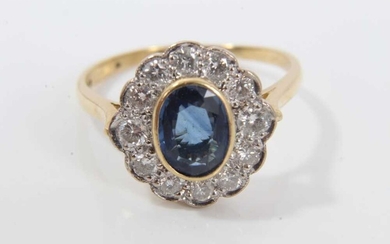 Sapphire and diamond cluster ring with an oval mixed cut blue sapphire measuring approximately 7.75mm x 5.75m x 2.8mm surrounded by twelve brilliant cut diamonds on 18ct yellow gold shank. Estimate...