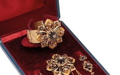Set in chiselled yellow gold and partially black enamelled amati, composed of a rush bracelet, a brooch and a pair of earrings decorated with rosettes and flowers set with rose-cut diamonds. Tower of poignet : 17 cm. Dimensions broche : 5.2 x 7.8 cm...