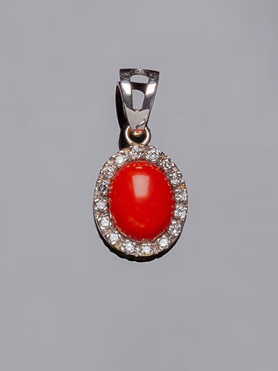 White gold pendant with oval coral cabochon and border...