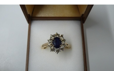 Yellow gold oval sapphire and diamond cluster ring. Sapphire...