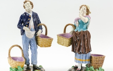 PAIR OF ENGLISH MAJOLICA FIGURES Modeled as a man and a woman in peasant costume, each with two baskets and standing on naturalistic...