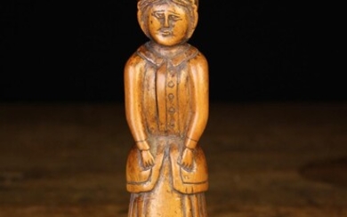 A 19th Century Carved Treen Folk Art Figure of a Woman in bonnet, standing on an octagonal base 7½''