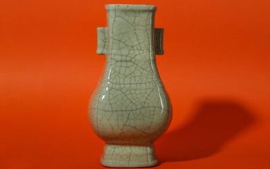 A CHINESE CRACKLE-GLAZE CELADON VASE, HU. The rectangular-section pear-shaped vase raised on a flared foot, with two double bands above the shoulder, the neck set with two tubular handles, all coated with a thick pale celadon glaze with a network of...