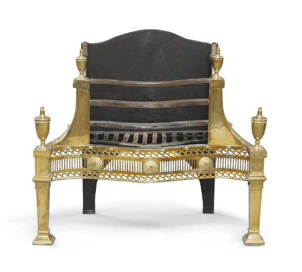 A George III style brass and cast iron fire grate, 19th century, the serpentine front with floral engraving and pierced apron, with urn shape finials, raised on square tapering supports and spade feet, 71cm high, 78cm wide, 33cm deep