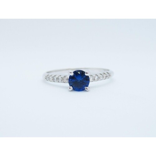 A Sapphire and Diamond Ring claw-set round sapphire with bri...