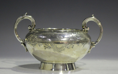 A Victorian silver circular two-handled sugar bowl, engraved with flowers and foliate scrolls, on a