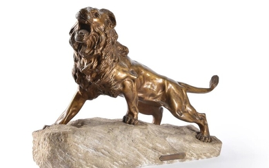 A bronze model of a lion on a stone base