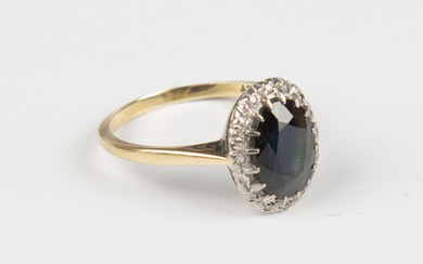 A gold, sapphire and diamond oval cluster ring, claw set with the oval cut sapphire within a surroun