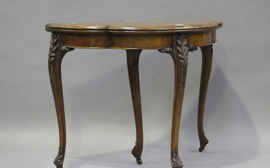 A mid-Victorian walnut fold-over card table with foliate inlaid decoration, on carved cabriole legs