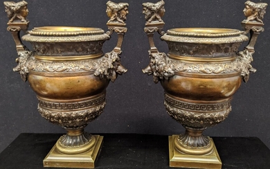 Une paire d'urnes en bronze du 19ème siècle, flanquées de têtes de sanglier, les terminaisons...