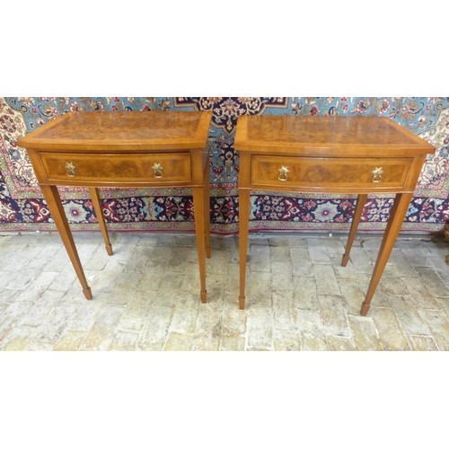 A pair of walnut bow fronted lamp tables, each with a frieze...