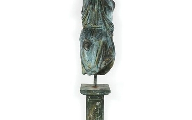 A patinated bronze draped female torso