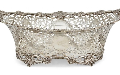 A pierced Edwardian silver basket, London, c.1905, C. S. Harris & Sons Ltd., designed in oval form with shaped floral edge to foliate pierced sides decorated with garlands, the body with vacant cartouches to either side, 33cm long, 11.5cm high...