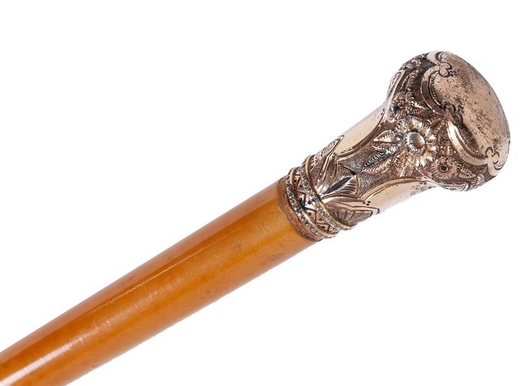 A wooden walking stick cane with golden handle...