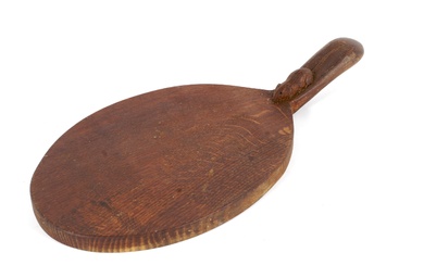 A workshop of Robert Mouseman Thompson (Kilburn) oak oval bread board. The handle carved with the signature mouse, 37cm long