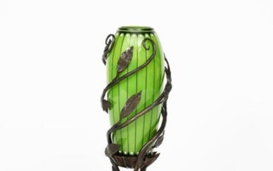 An Austrian Secessionist glass vase with wrought iron mount, slender, swollen green cylindrical glass body with enamelled black and white design, set in wrought iron foliate stand unsigned, 30cm. high