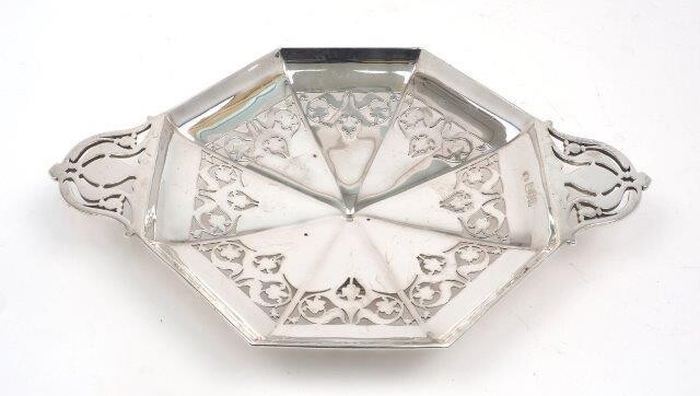 An Edwardian pierced silver dish, London, 1904, Sibray, Hall & Co., of octagonal form with twin handles and a circular foot, 29cm wide (inc. handles, 4cm high, approx. weight 14.8oz